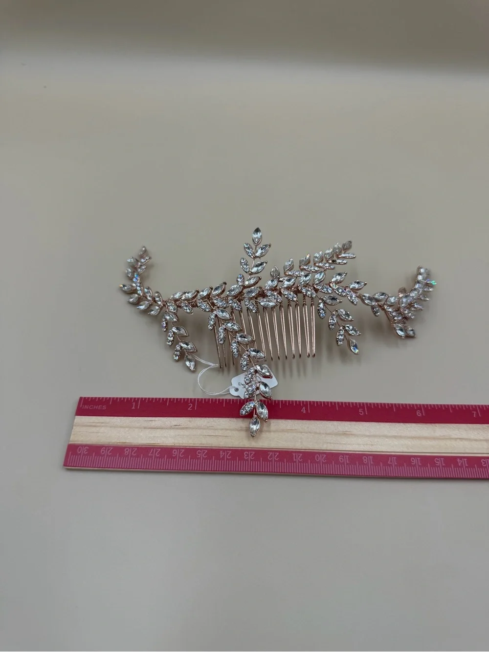 Elegant rose gold-tone bridal hair comb featuring a cascading leaf-and-vine desi